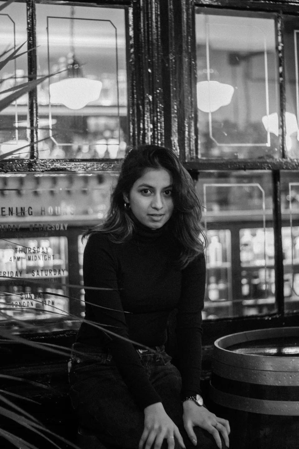 Black and white portrait of Shrinkhla seated outside a café