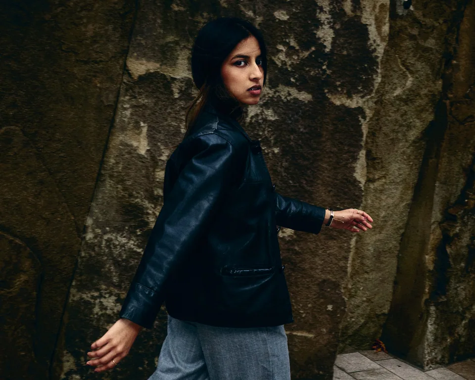 A walking portrait of Shrinkhla in a leather jacket